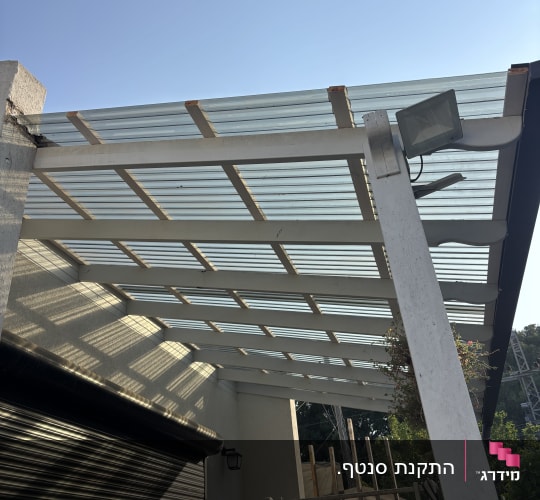 פרגולה מעץ עם גג שקוף בחצר